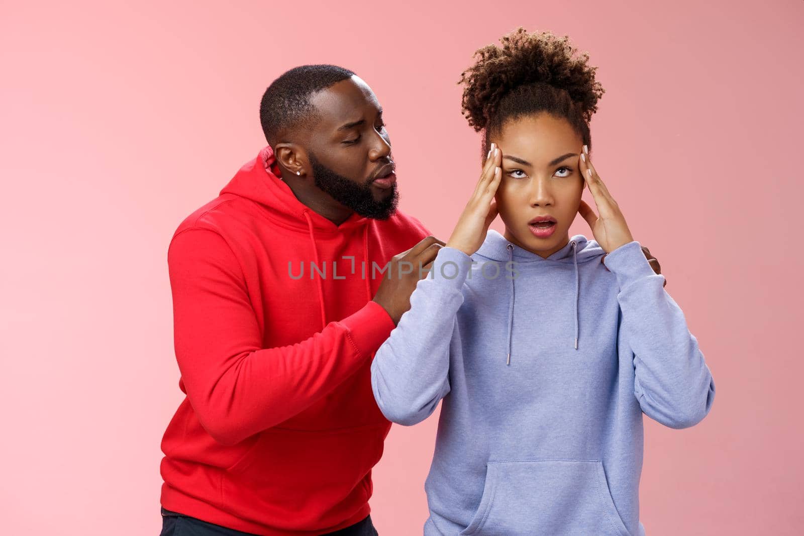 Man apologizing girlfriend behind back touching shoulder comforting girl feel pressured irritated fed up lying hear boyfriend sorry arguing standing bothered pink background, couple fighting by Benzoix