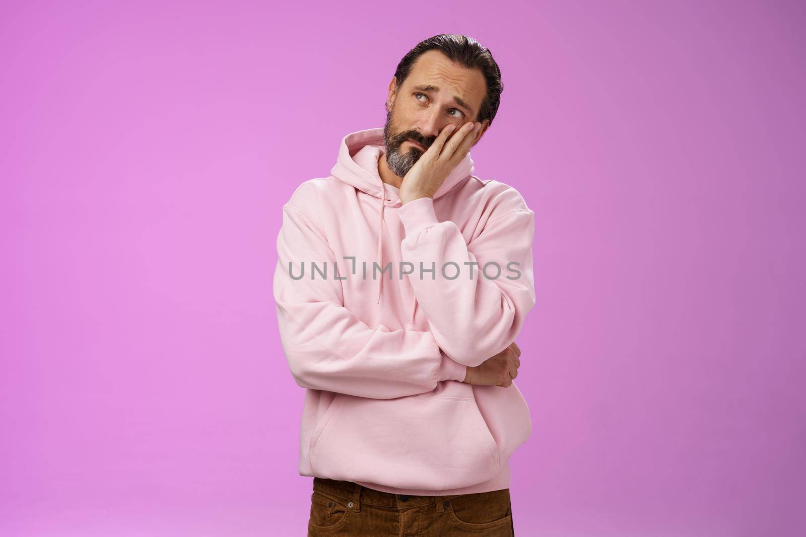 Sad gloomy bearded mature man lean head palm frowning look upper left corner thoughtful sorrow thinking bad times face hard problem standing upset disappointed down dumps, purple background by Benzoix