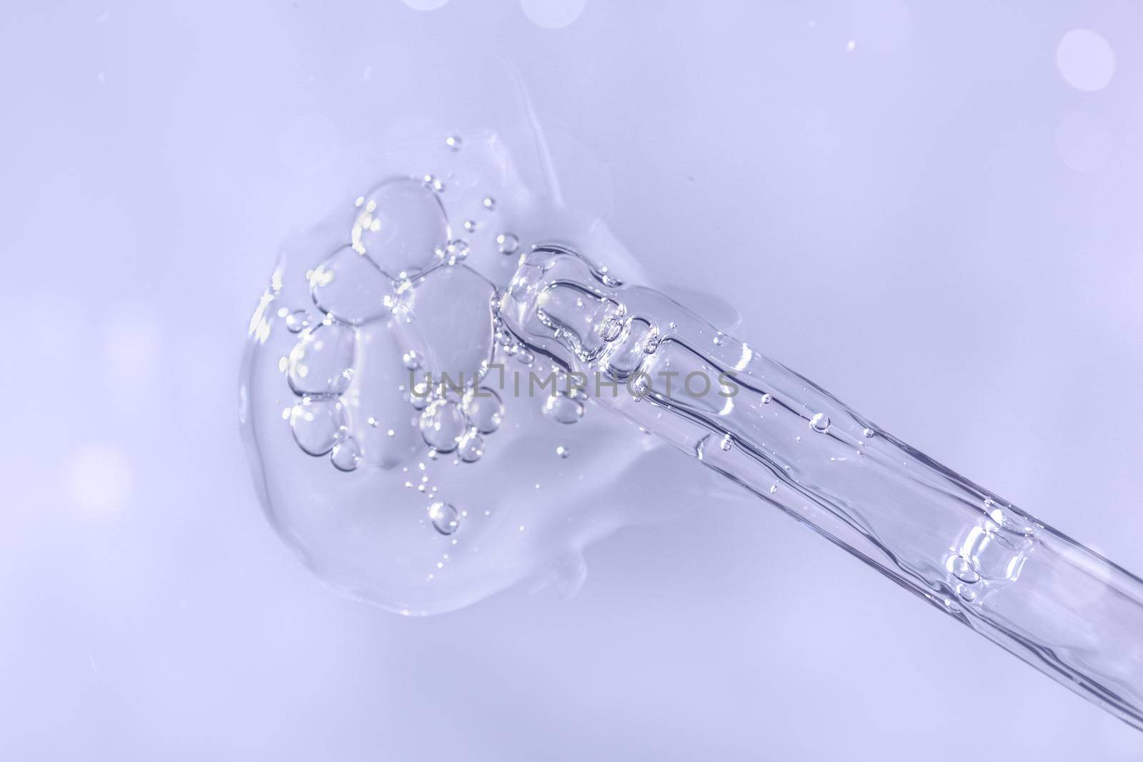 Pipette with fluid hyaluronic acid on violet background. Cosmetics and healthcare concept closeup. Dose of serum or retinol with air bubbles. Flat lay. Luxury beauty product presentation in macro
