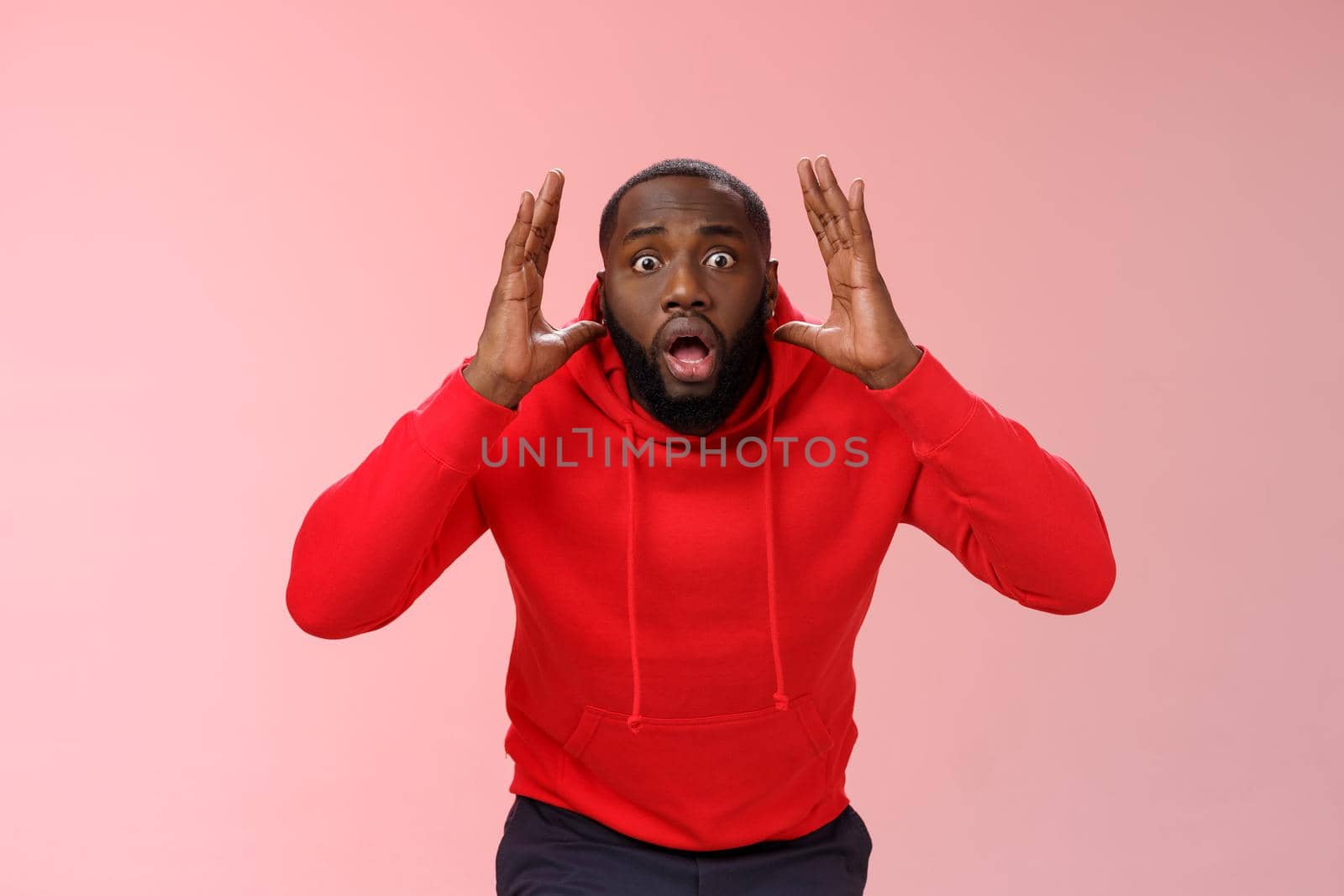 Freaked out panic worried young insecure african american man go crazy acting weird bending camera anxious terrified raise hands head widen eyes shocked, standing pink background worn people danger by Benzoix