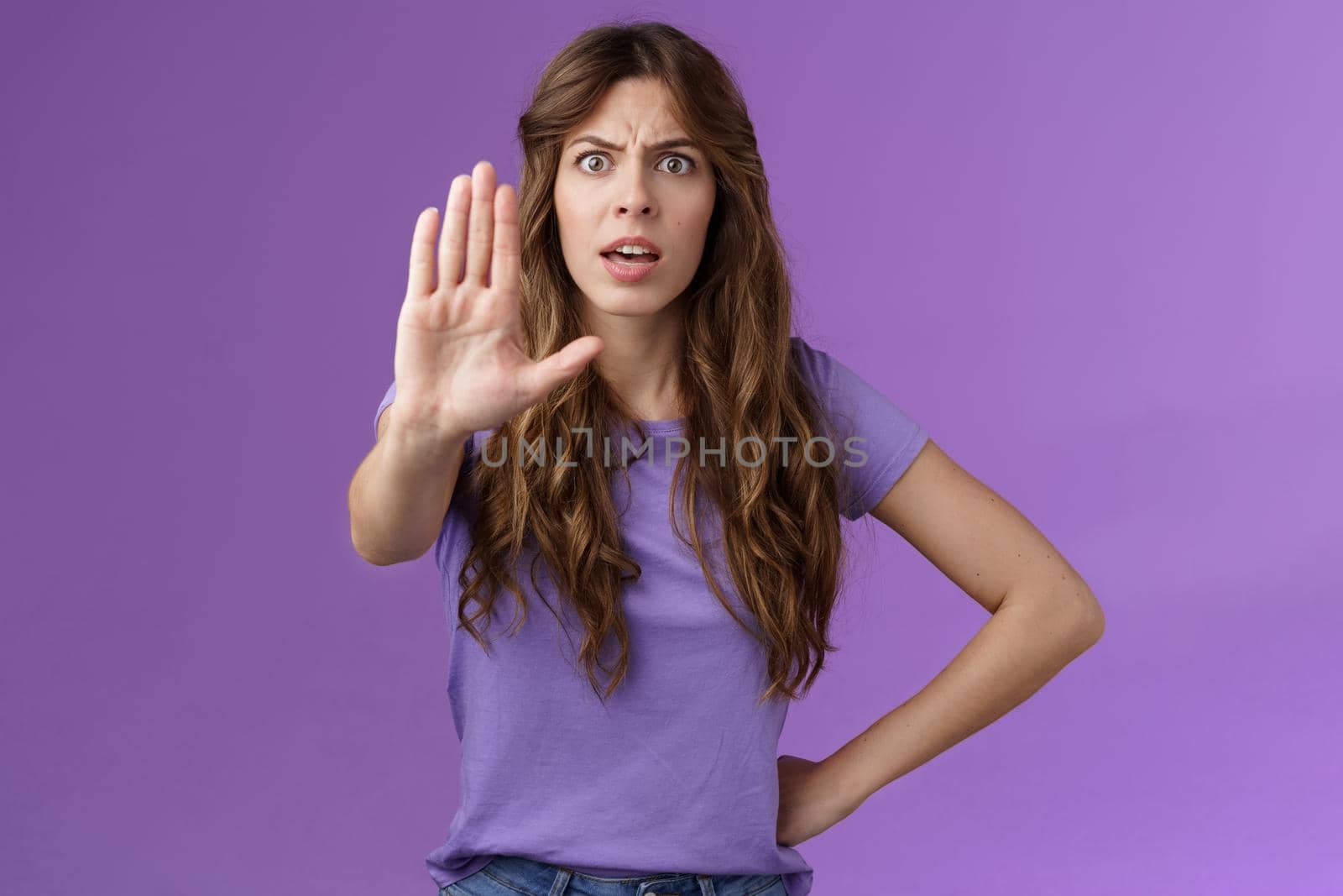 Serious-looking displeased assertive female friend stand confident demand stop smoking pull palm camera forbid disapproval gesture restrain you making bad choice purple background.