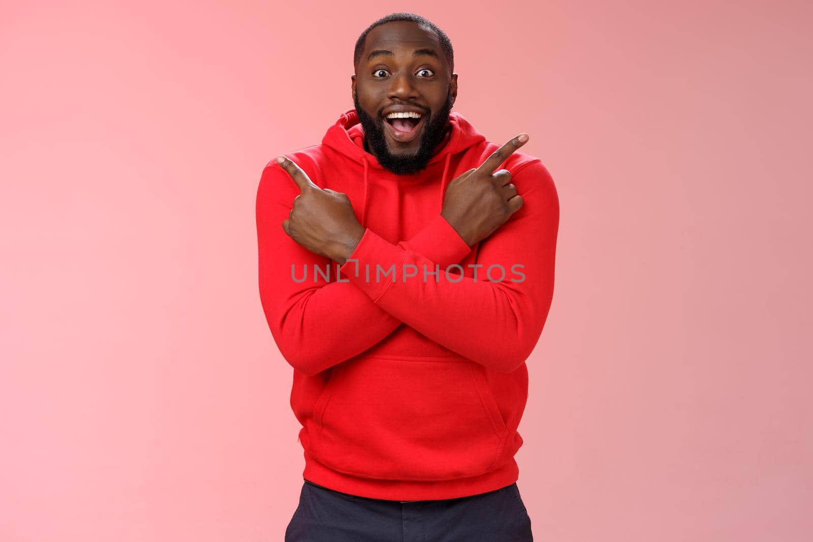 Glad amazed good-looking happy black male customer bearded widen eyes surprised joyfully pointing both sides left right cross arms chest impressed variety cool products, standing pink background by Benzoix