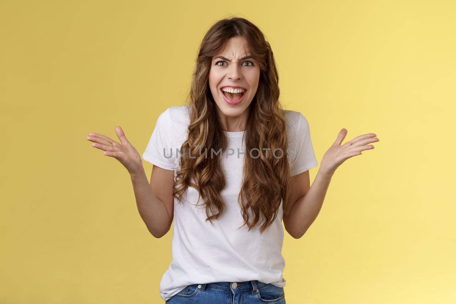 Disappointed angry furious woman shrugging hands sideways dismay frustration shouting complaining feel outraged pissed arguing scream intense rage stand yellow background quarrel by Benzoix
