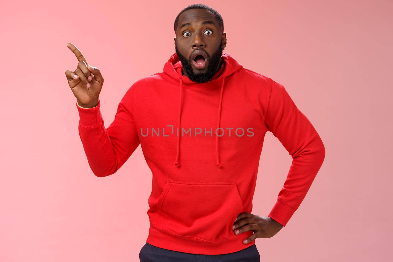 Shocked astonished black bearded young guy drop jaw gasping speechless pointing upper left corner widen eyes impressed cannot believe saw miracle look camera questioned unbelievable sales.