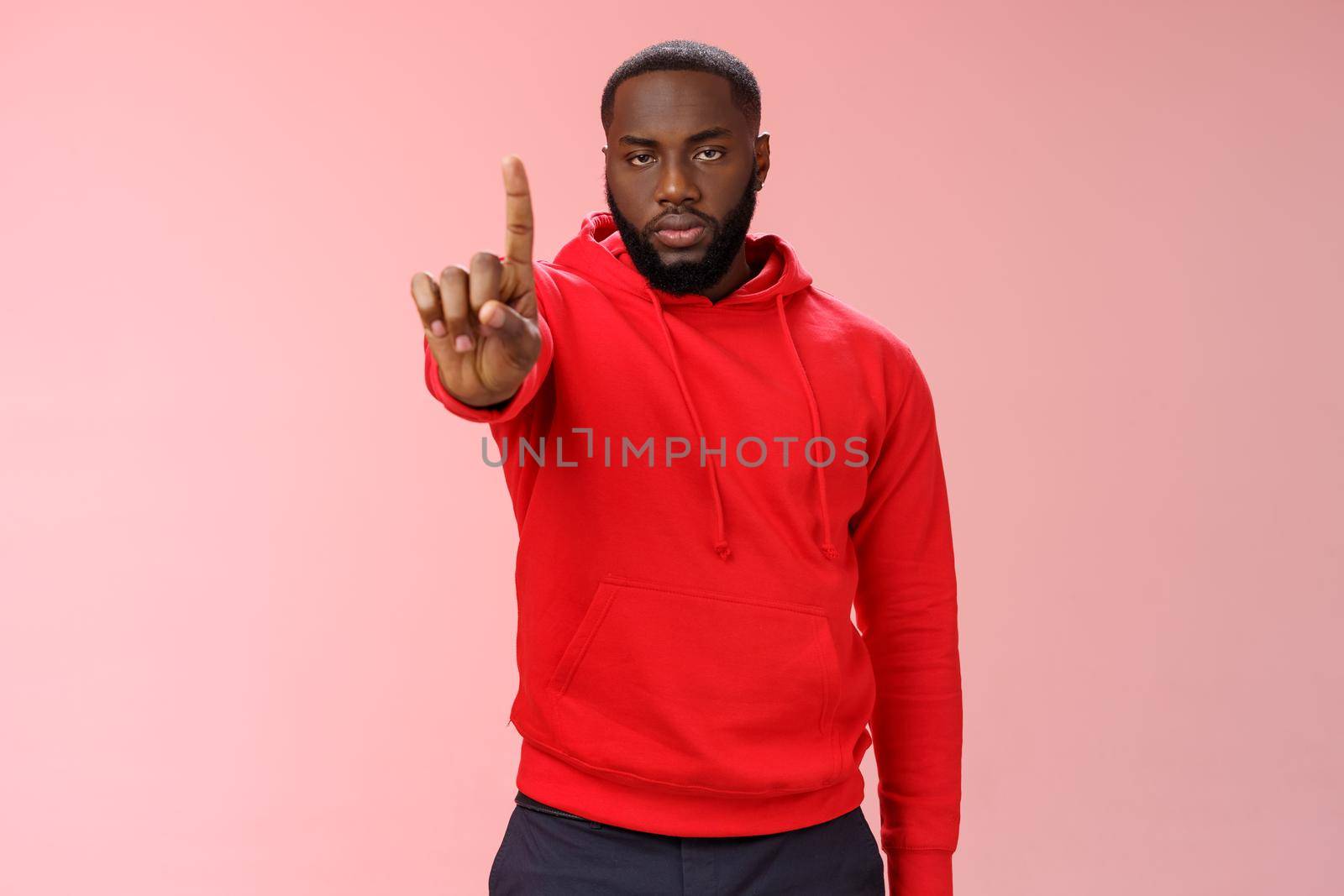 Wait second. Serious-looking annoyed strong brutal african american older brother show index finger number one explaining important rule look bossy solid, standing pink background forbid something by Benzoix