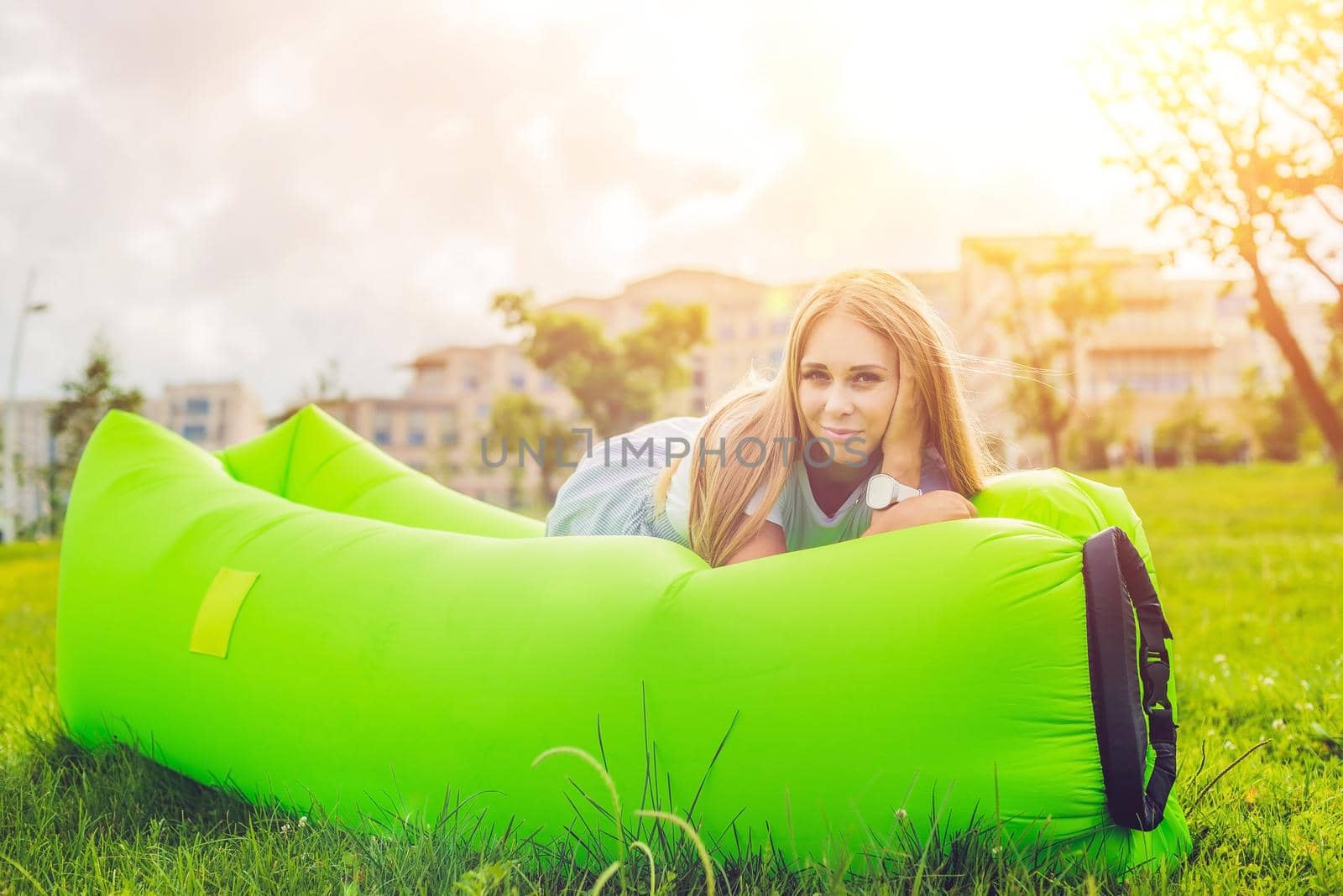 Young woman resting on an air sofa in the park.. lamzac