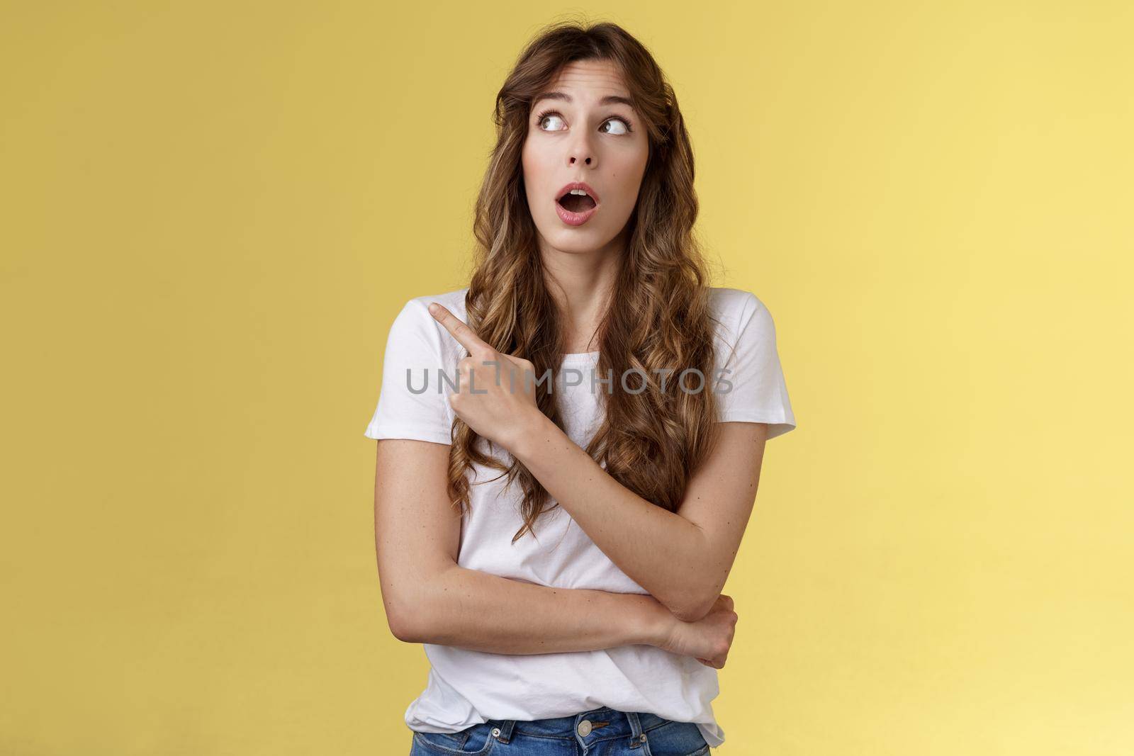 Omg wow no way. Impressed speechless stunned pretty european girl drop jaw astonished open mouth intrigued stare pointing upper left corner admiration surprised glancing curiously yellow background by Benzoix