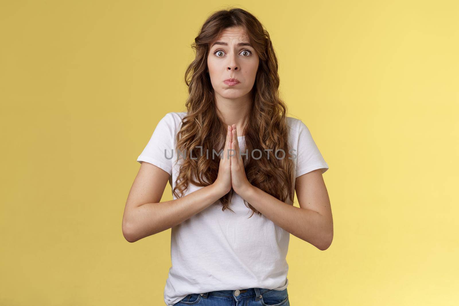 Pretty please beg you help me. Innocent cute lovely upset caucasian girl begging pleading your mercy pulling face hope for pity apologizing puppy eyes frowning need urgent advice yellow background.