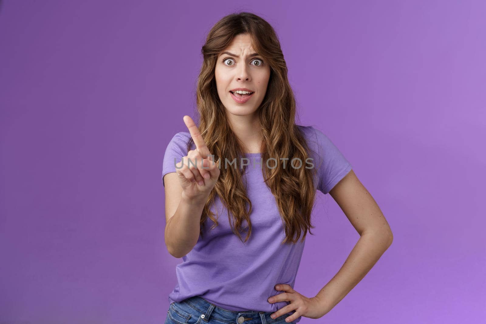 Displeased offended serious-looking assertive woman forbid express dislike and disapproval frowning annoyed shaking index finger prohibit refusing offensive behaviour stand purple background by Benzoix