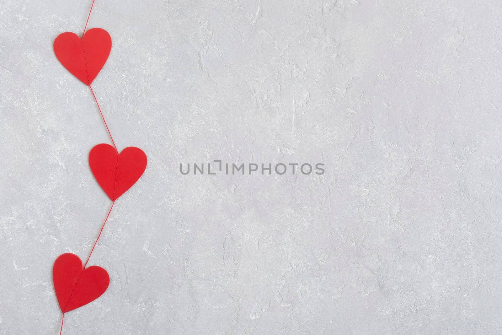 red hearts garland, Valentine Day concept, minimalism, grey concrete background, copy space