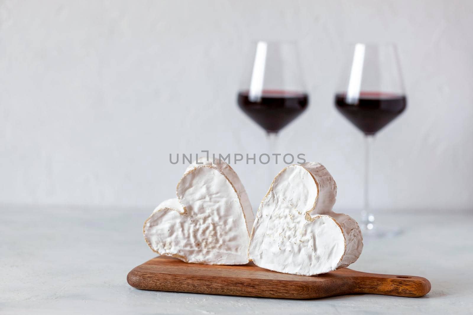 soft heart shaped cheese and red wine glasses, Valentine Day concept, side view,