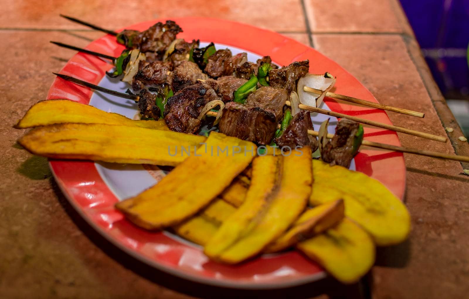 Roast beef skewers served on a silver, roast beef on skewers served with fried plantain
