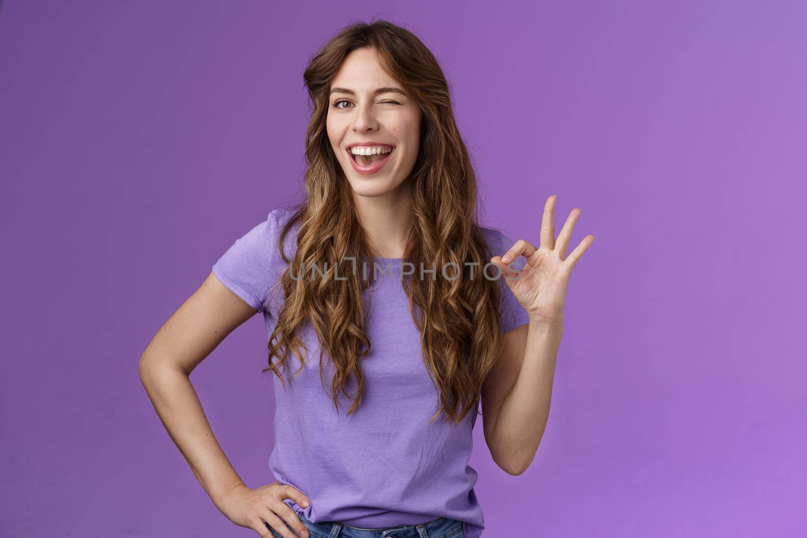 Okay got it. Cheeky flirty girlfriend winking coquettish show alright okay ok sign smiling broadly reassure friend outfit awesome express approval agree good idea stand purple background pleased by Benzoix