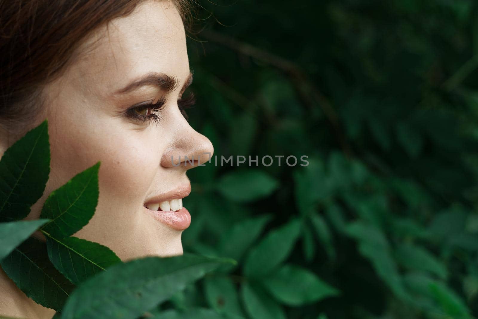 portrait of a woman Cosmetology nature green leaves glamor close-up. High quality photo