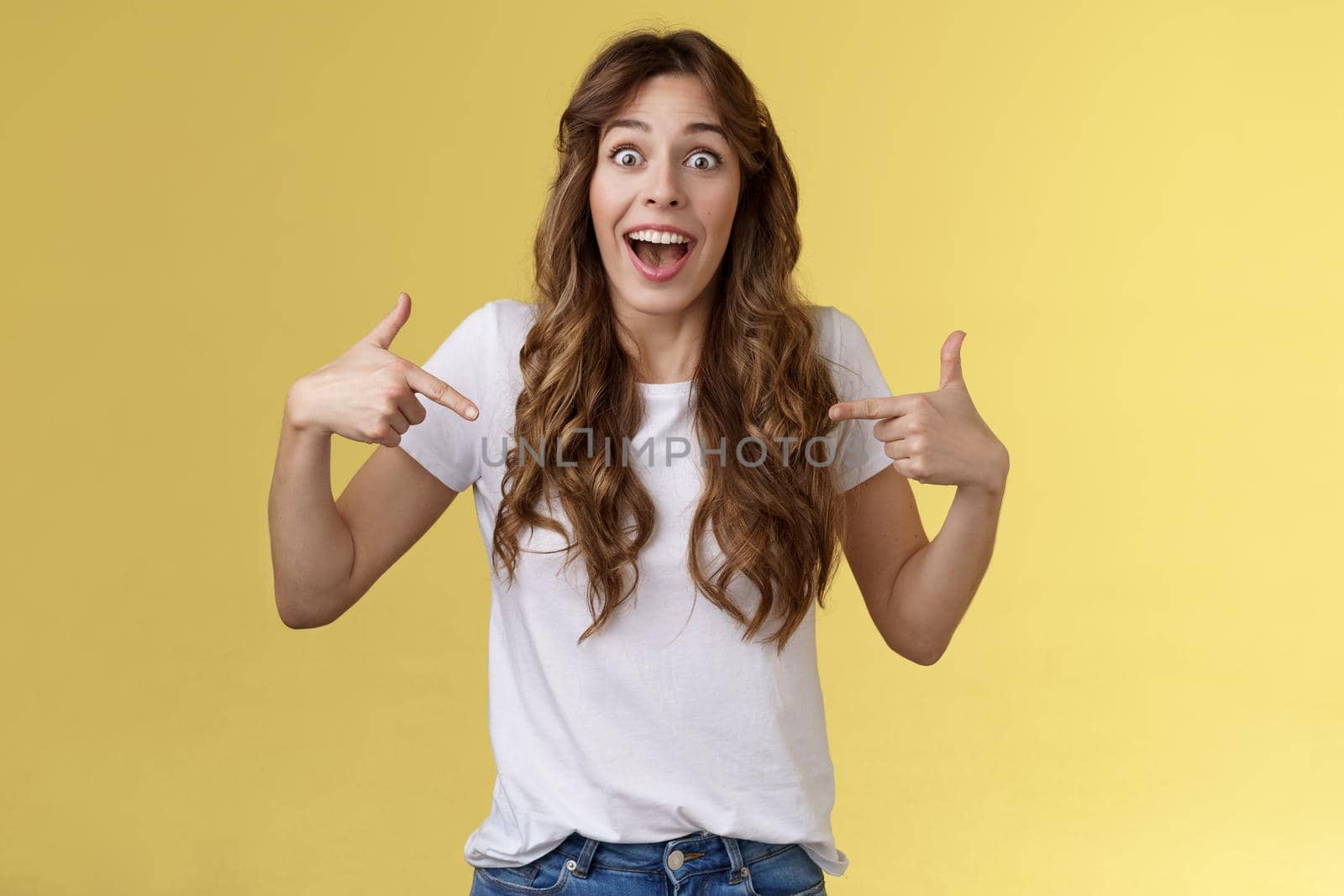 Can you believe, fascinating. Impressed sociable cute girl telling friend excellent near being picked got job pointing index fingers herself center copy space white t-shirt stare surprised smiling.