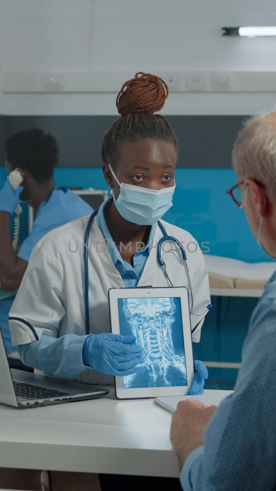 Young doctor analyzing x ray on digital tablet by DCStudio