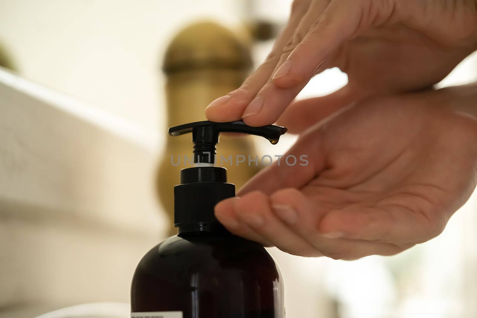 The girl washes her hands with liquid soap under water, the woman takes care of her health and cleanliness, disinfects her hands.