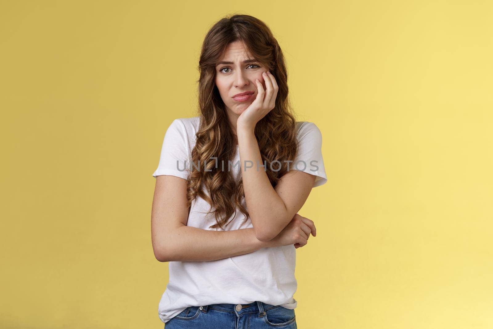 Upset distressed cute disappointed pretty girl feeling lonely regretting missed opportunity sighing sorrow sadness look camera apathetic indifferent lean face palm frowning jealous yellow background by Benzoix