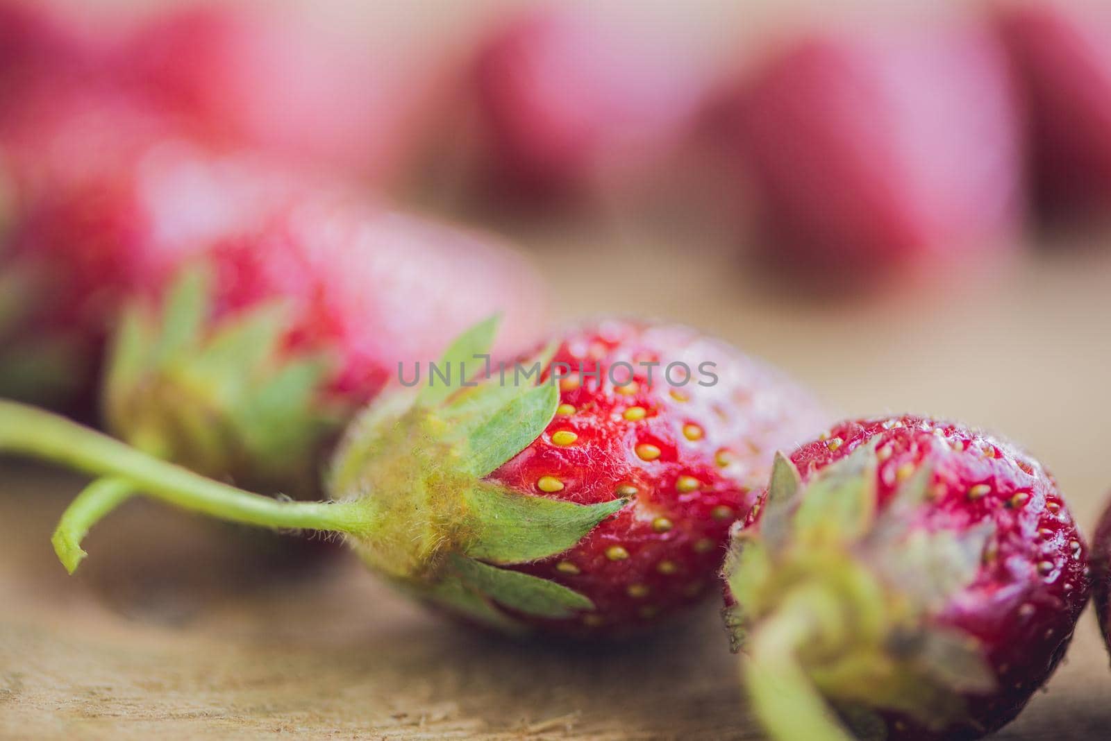 Fresh organic strawberry close-up on an old wooden background.