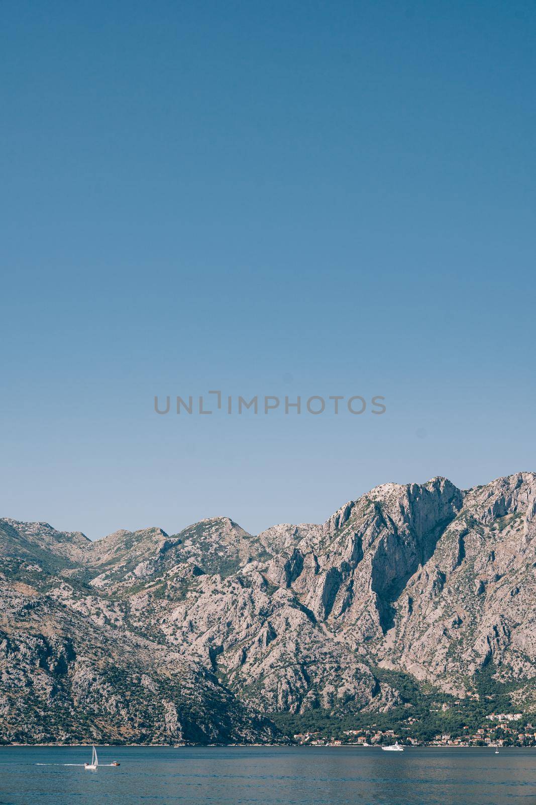 Huge mountain range on the shore of the Kotor Bay against the background of blue sky. High quality photo
