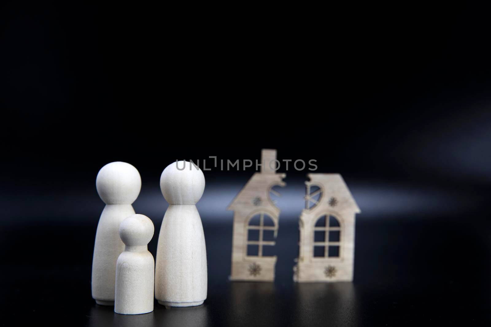 Divorce, division of property, poverty and no money concept. Wooden broken house on black background. Mortgage, rent, realtor concept copy space space for text