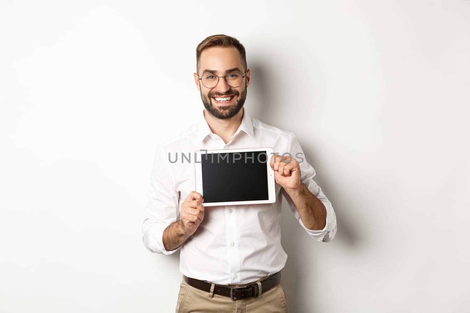 Shopping and technology. Handsome man showing digital tablet screen, wearing glasses with white collar shirt, studio background.