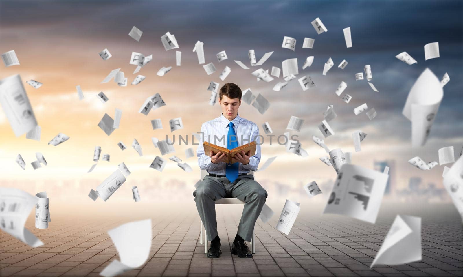 young businessman with book on office chair