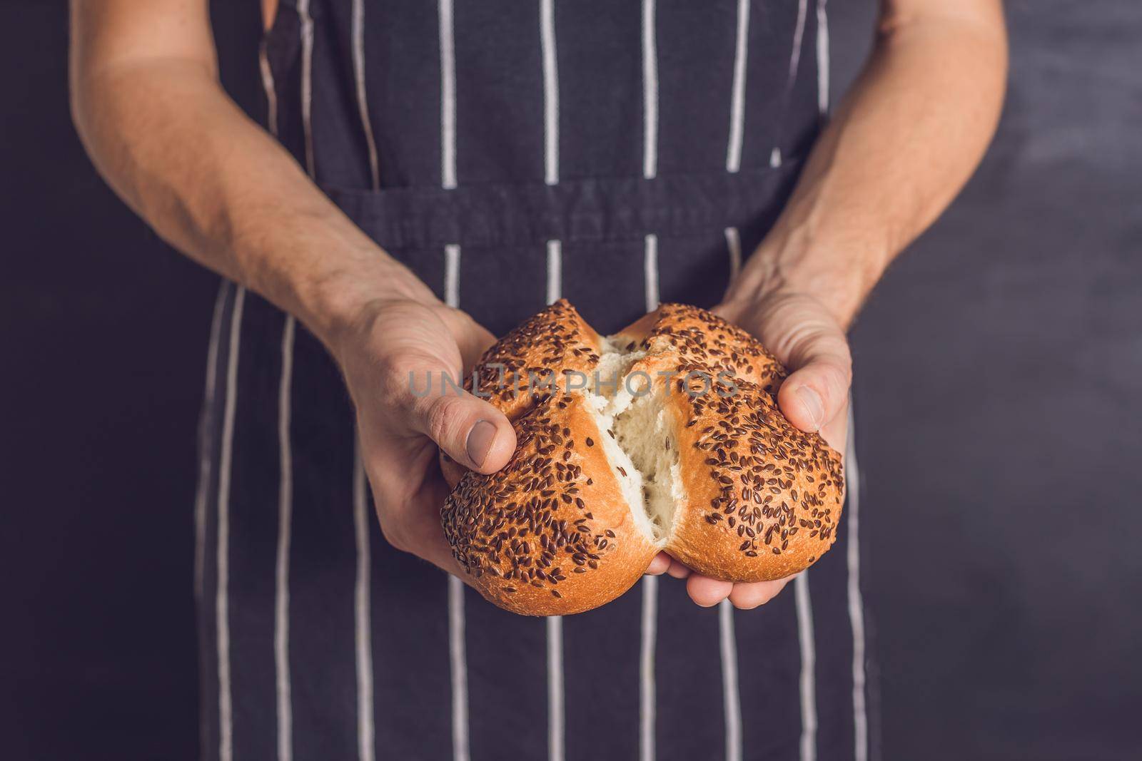 Bread with flax seeds in the hands of a baker.