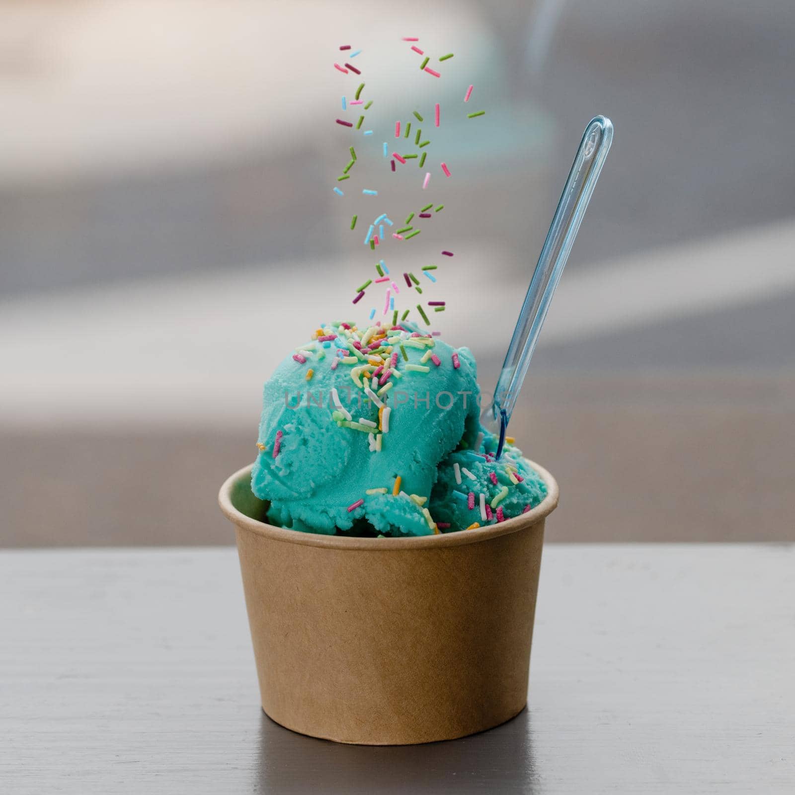 ice cream with mint and sprinkling in paper cup on table in cafe