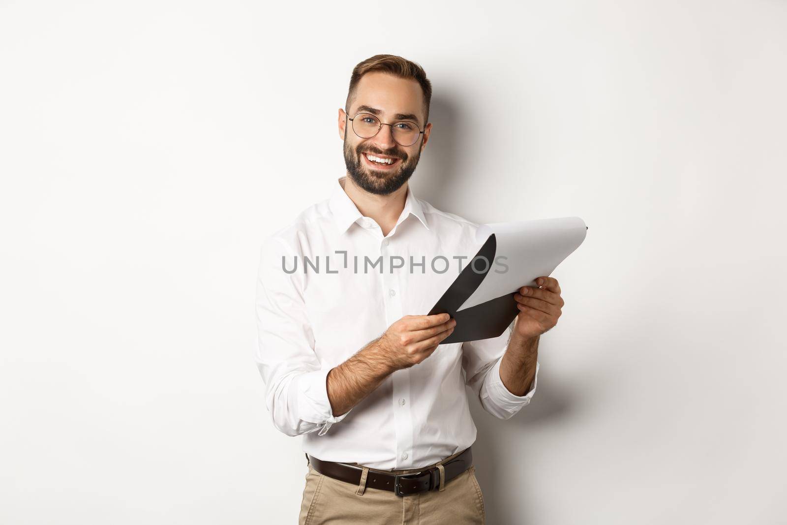 Employer looking satisfied at CV, reading document and smiling, standing over white background by Benzoix
