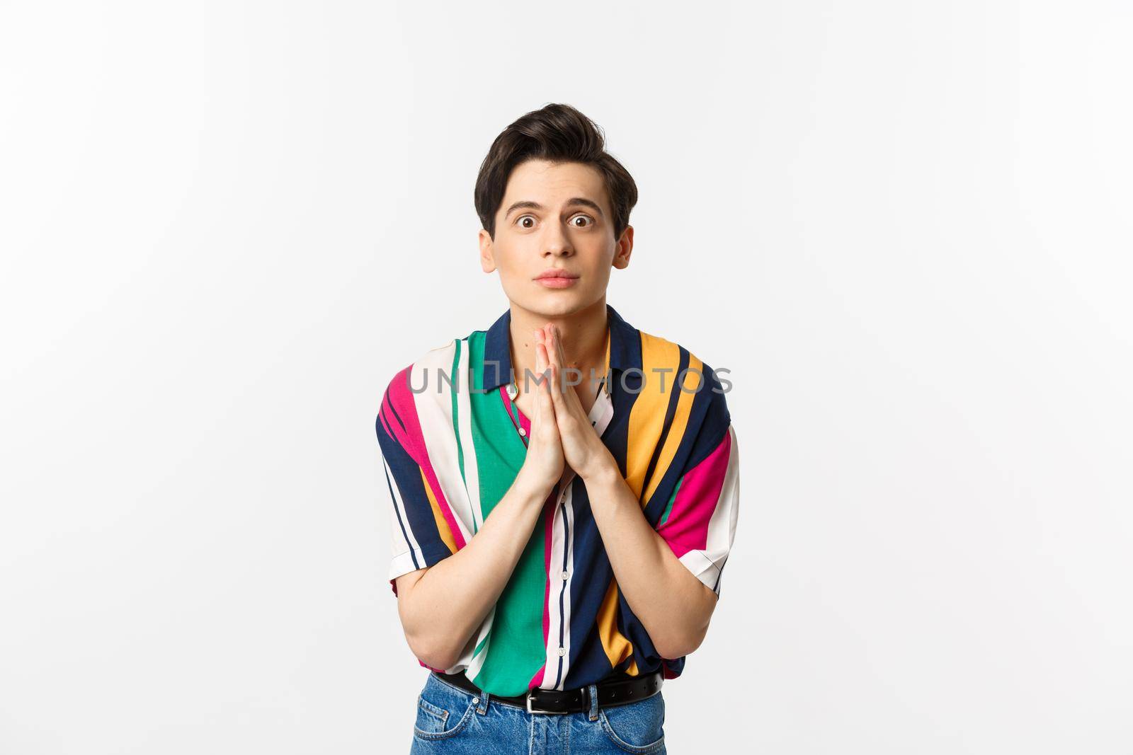 Image of hopeful young man begging for help, staring at camera and pleading for favour, asking advice, standing over white background by Benzoix