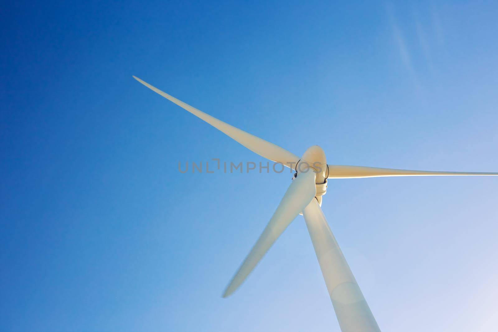 Wind turbines generating electricity with blue sky - energy conservation concept.