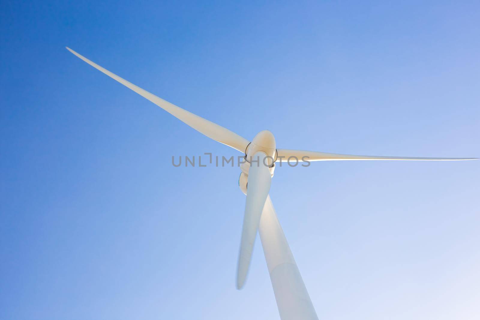 Wind turbines generating electricity with blue sky - energy conservation concept.