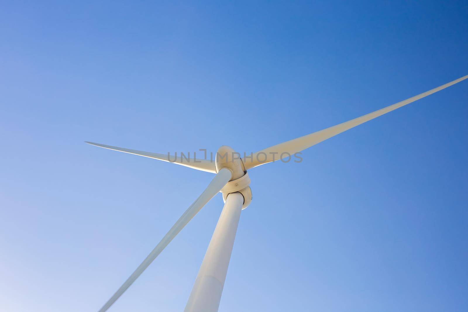 Wind turbines generating electricity with blue sky - energy conservation concept.