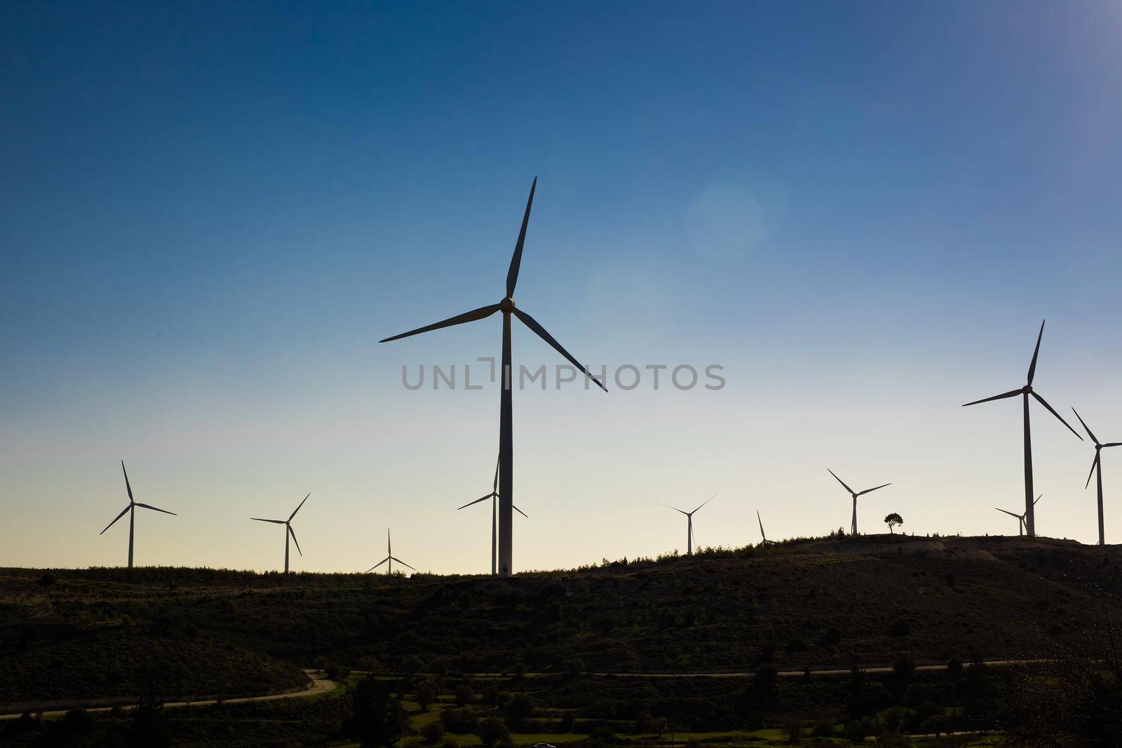 Wind turbines generating electricity with blue sky - energy conservation concept.