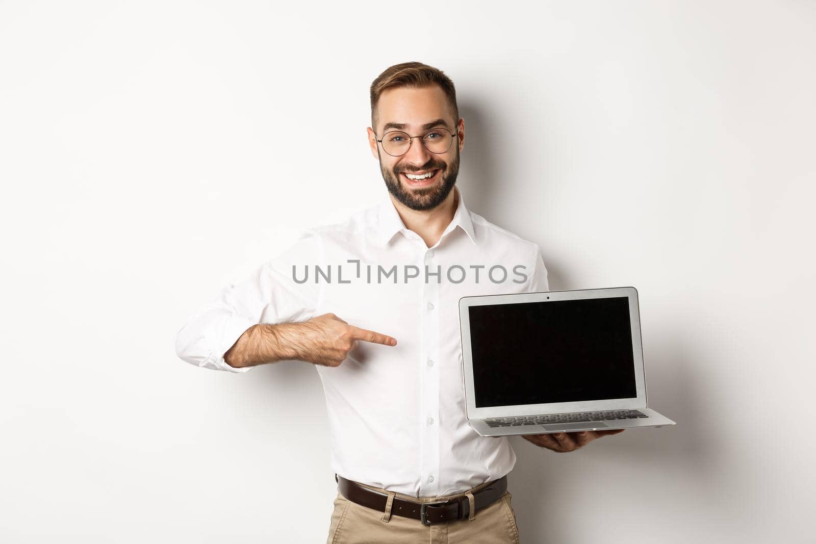 Professional manager showing webpage on laptop screen, pointing at computer, standing over white background by Benzoix