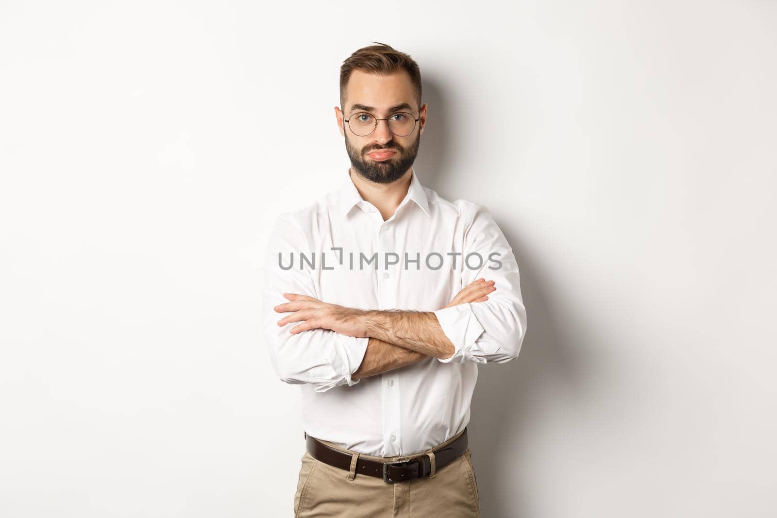 Disappointed businessman pouting, standing displeased against white background. Copy space