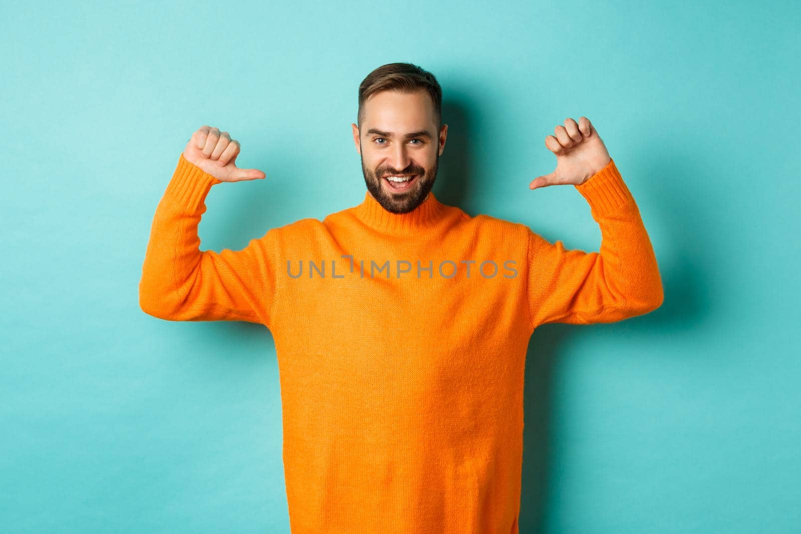 Handsome confident man pointing at himself, looking self-assured, standing in orange sweater against light blue background by Benzoix