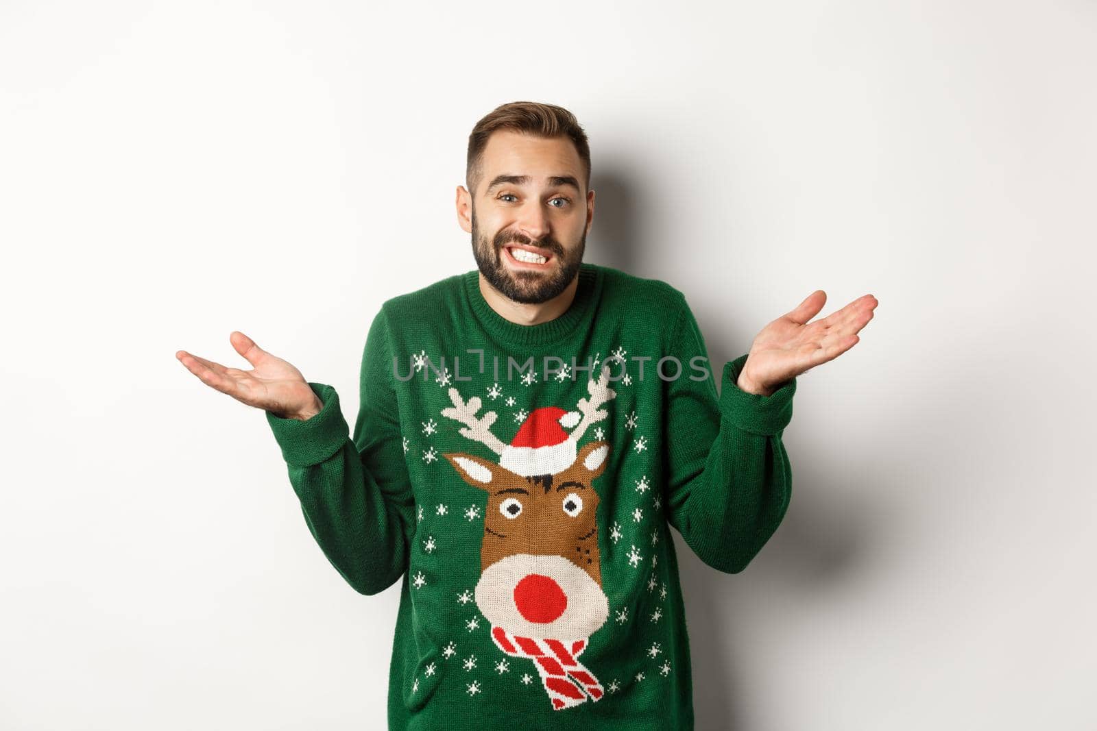 New Year, holidays and celebration. Confused bearded man shrugging, dont know anything, standing clueless against white background.