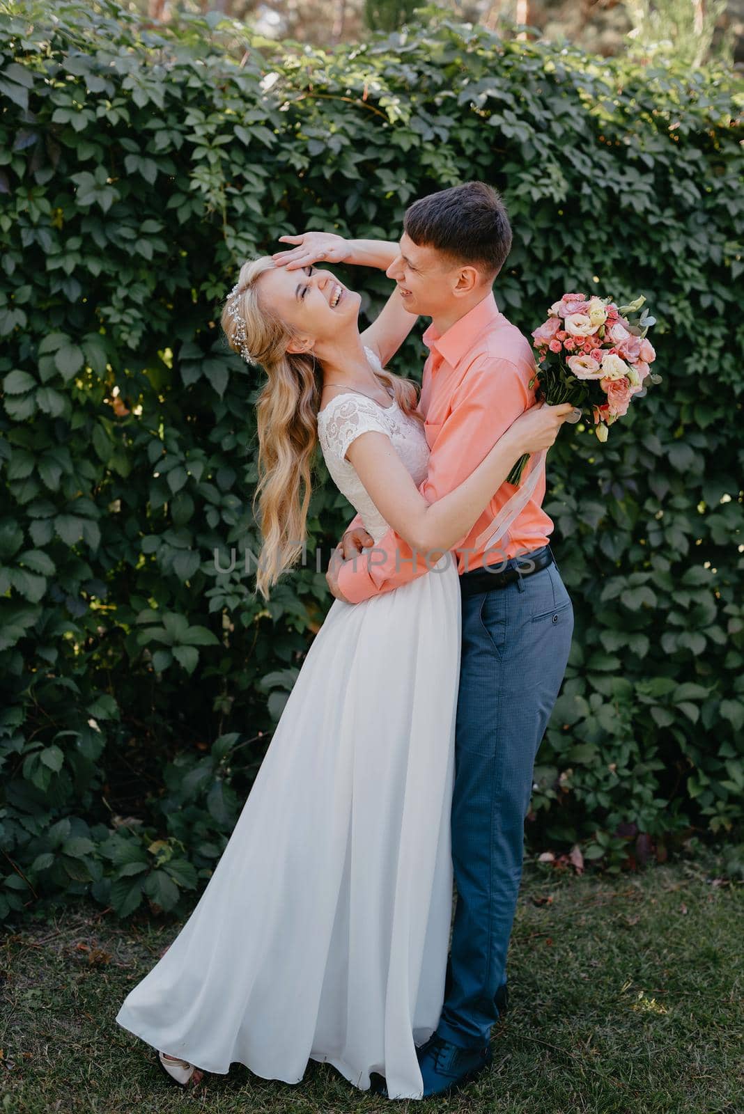 Bride and groom at wedding Day walking Outdoors on spring nature. Bridal couple, Happy Newlywed woman and man embracing in green park. Loving wedding couple outdoor. Wedding shot of bride and groom in park. Elegant bride and groom posing together outdoors on a wedding day. wedding couple in the park by Andrii_Ko