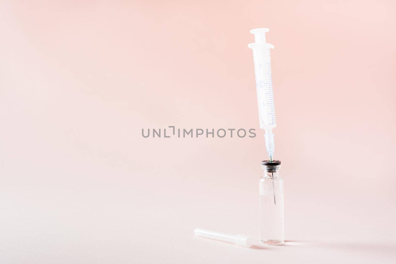 Vaccination and Immunization. Syringe needle inserted into a glass vial with vaccine by Aleruana