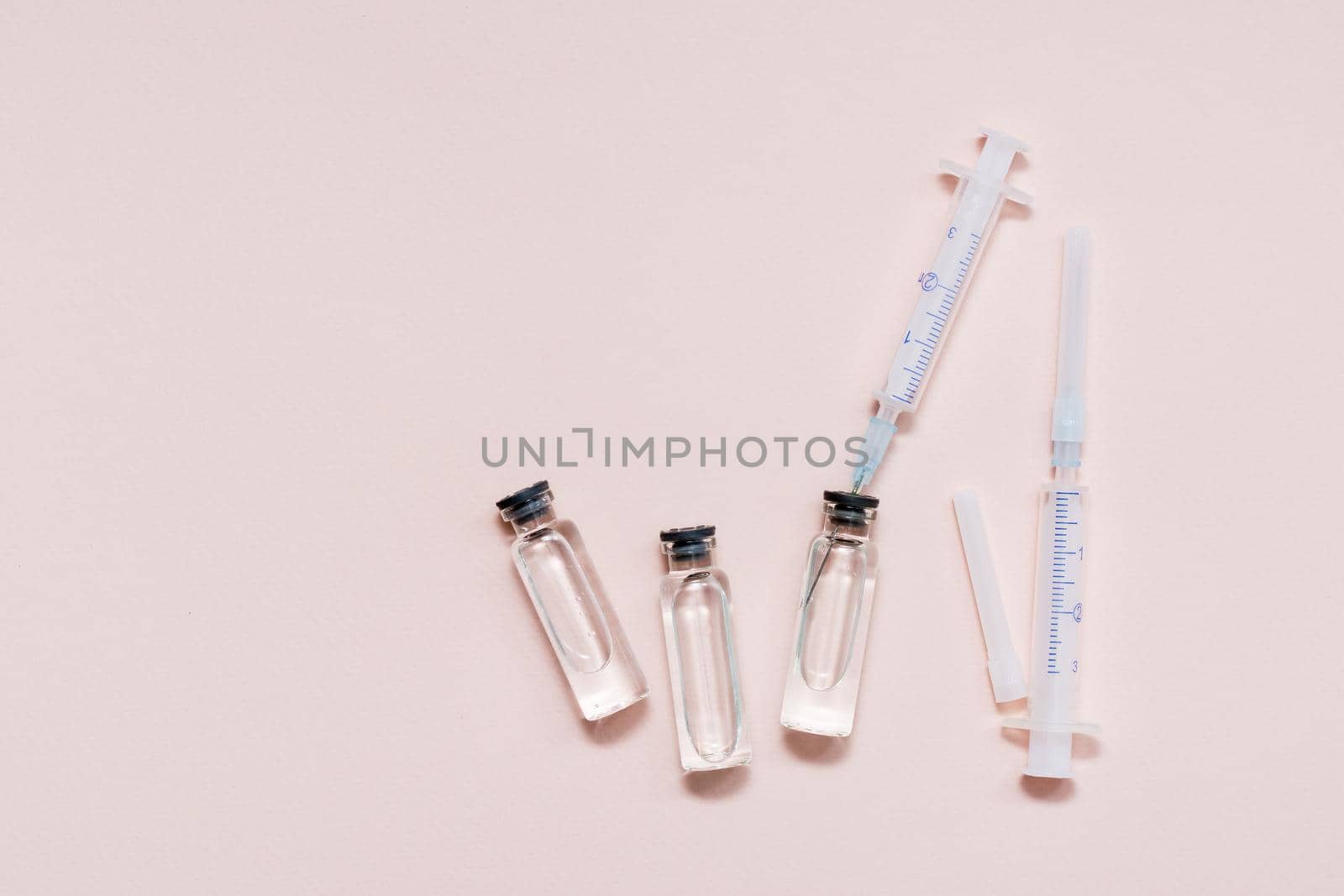 Vaccination and Immunization. Syringe needle inserted into a glass vial with vaccine. Top view