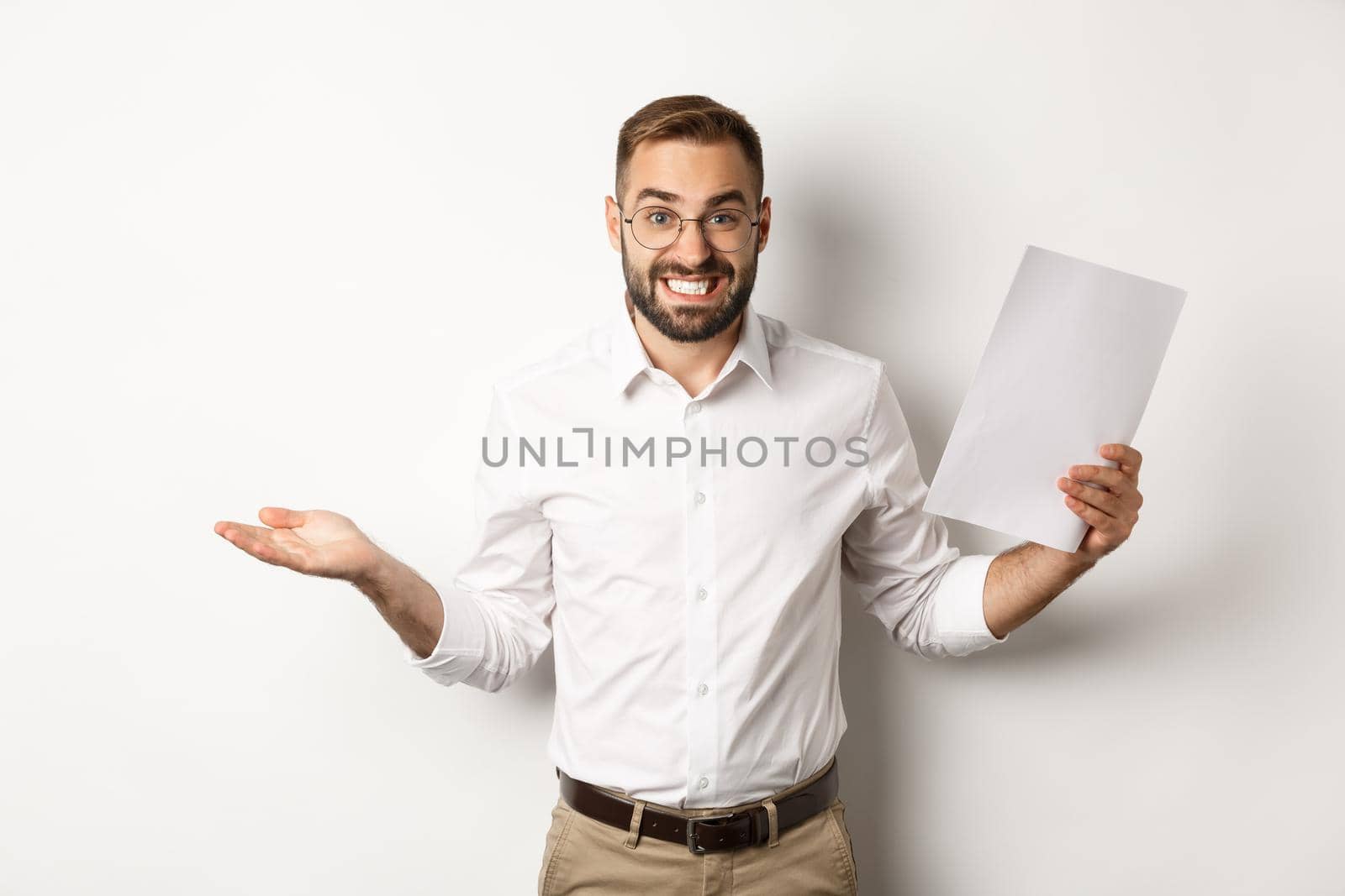 Awkward manager showing document and shrugging, looking guilty of mistake, standing over white background.