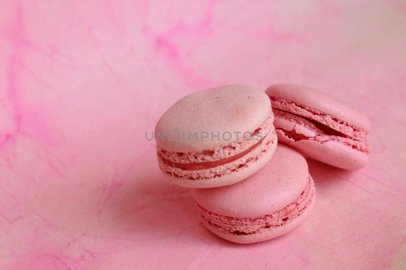 Beautiful card with three pink macaroon cakes on pink background. Abstract background. Creative concept design. Design element.