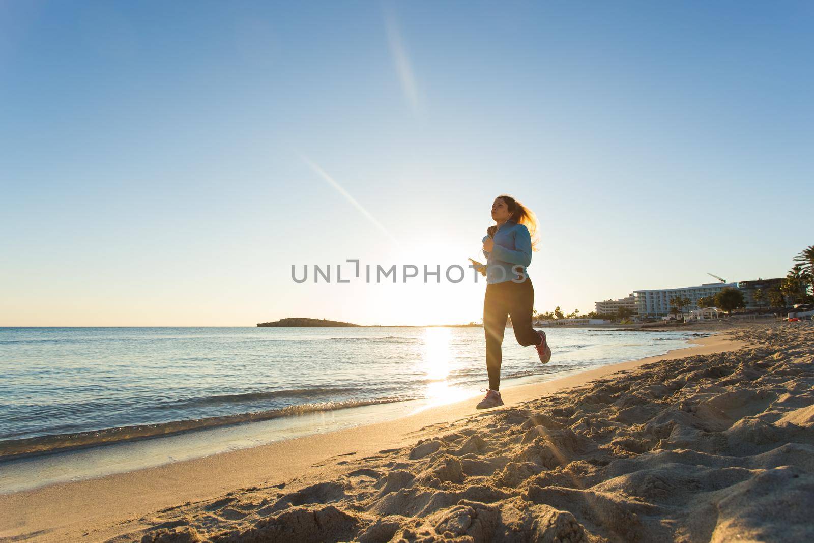 young healthy lifestyle fitness woman running at sunrise beach.