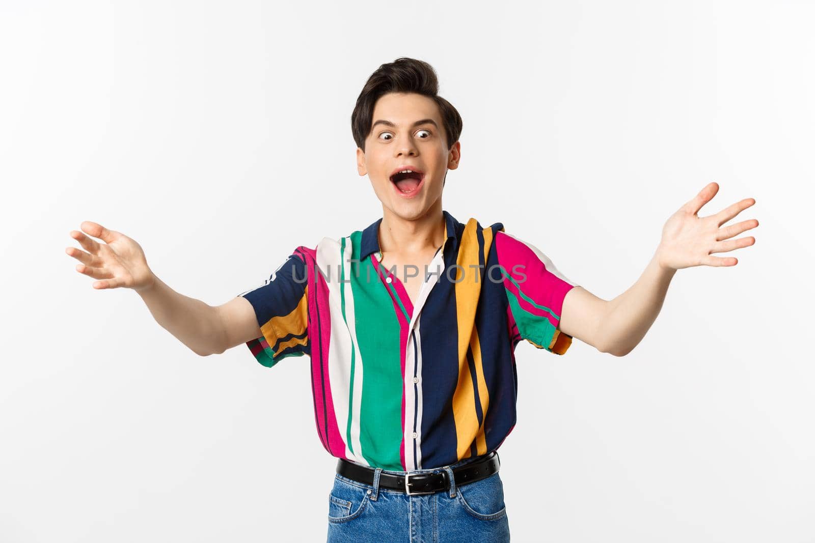 Amazed funny guy spread hands sideways and screaming of excitement, reaching for what he wants, standing over white background.