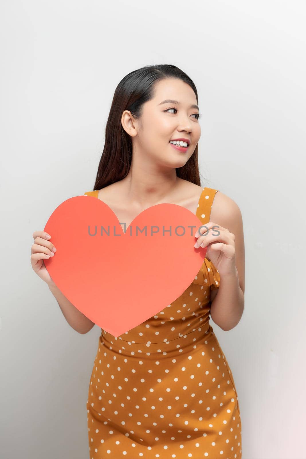 young asian woman holding a red heart shape by makidotvn