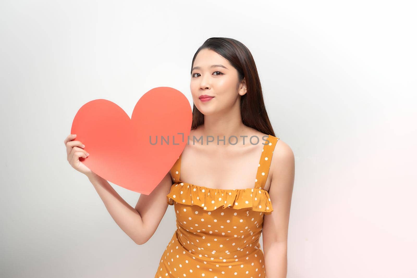 portrait of a pretty woman holding a paper heart on white background by makidotvn