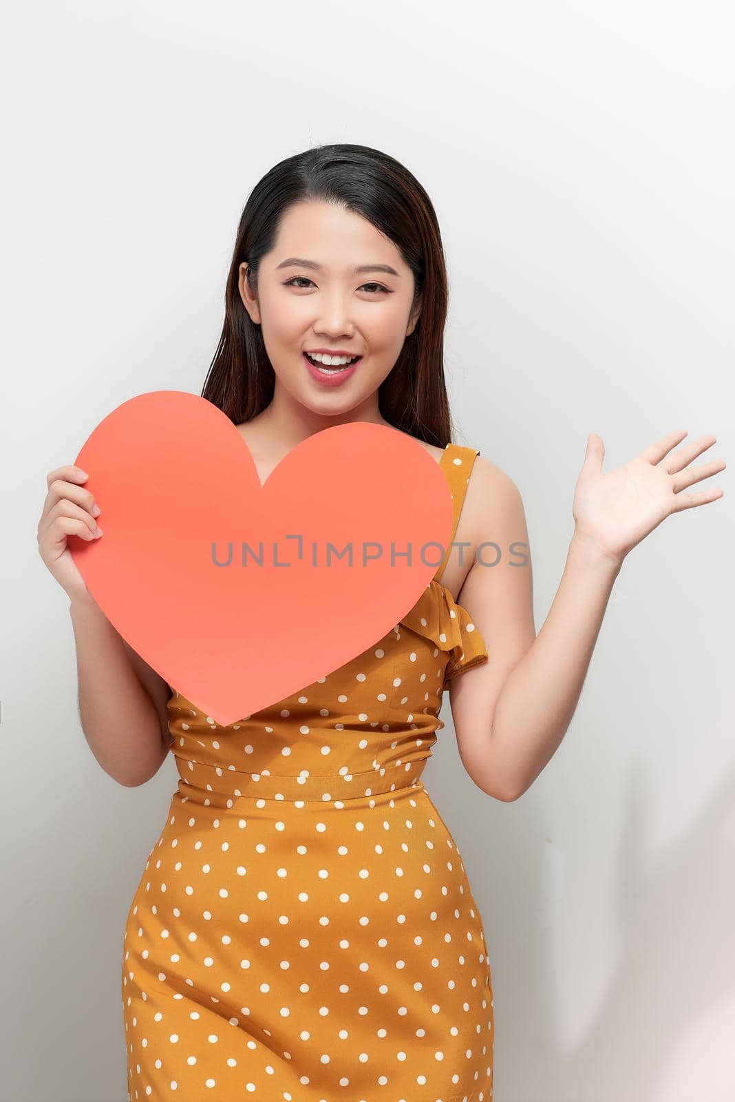 portrait of happy asian woman holding red heart symbol by makidotvn