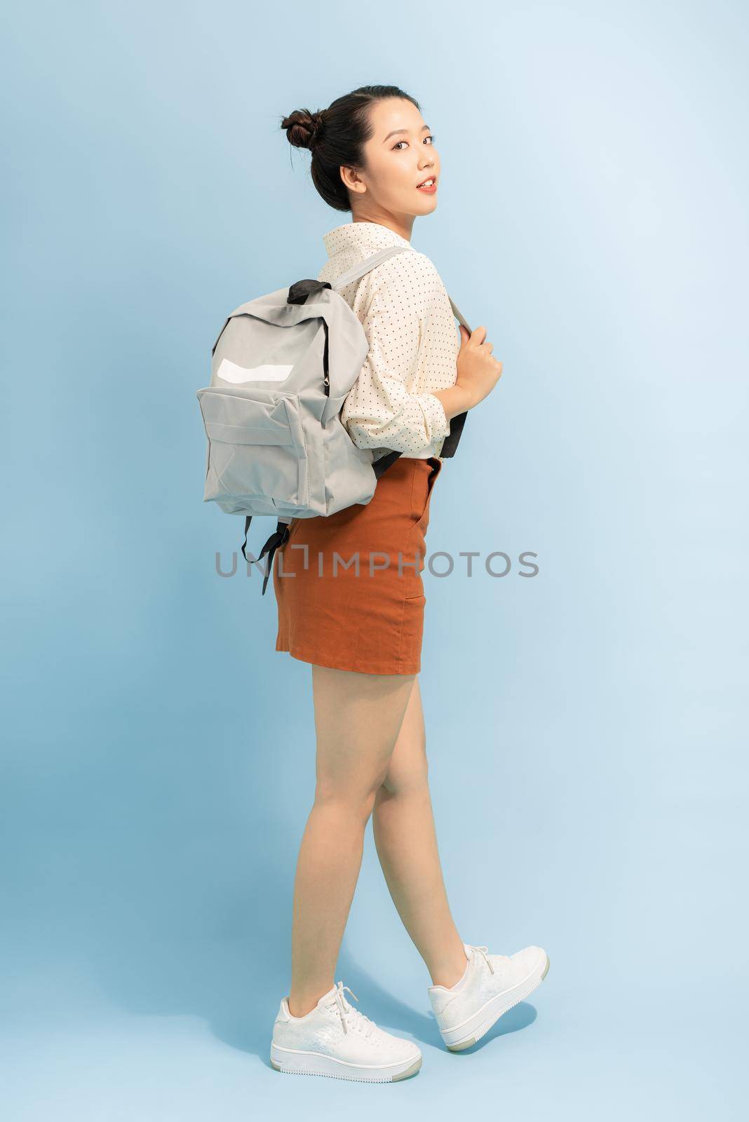 Happy smiling young cute asian student girl with backpack. Beautiful woman tourist. Study or travel
